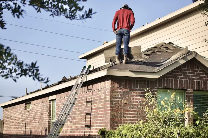 Professional roofer working on a residential roof in Wiley